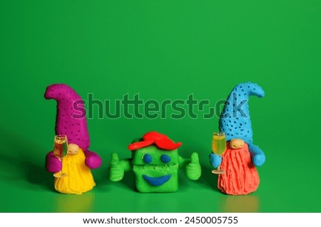 Two toy dwarfs made of plasticine with glasses of champagne. New Year's holidays and Christmas. Decorations and decorations.