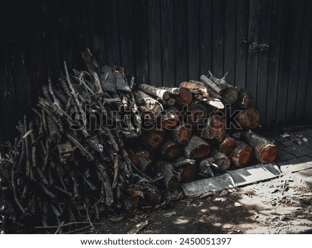 Woodpile outside the door of a wooden hut - conceptual winter fine art image in horizontal format for background use