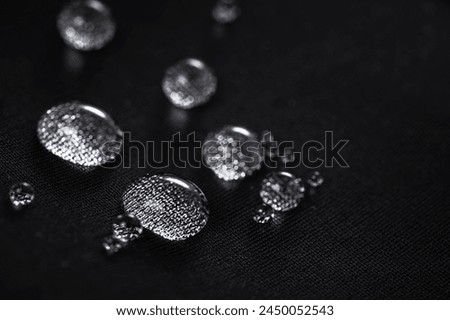 Many water drops on waterproof impregnated fabric. Royalty-Free Stock Photo #2450052543