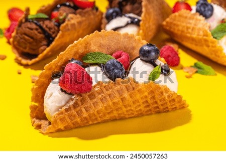 Various sweet taco ice creams. Waffle taco shells with chocolate and vanilla flavour ice cream with different fruits, berry, toppings