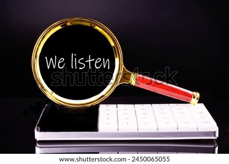 The words WE LISTEN through a magnifying glass on a black background in white font