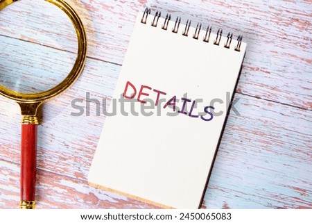 Business concept. DETAILS word on a notebook near a magnifying glass on the boards