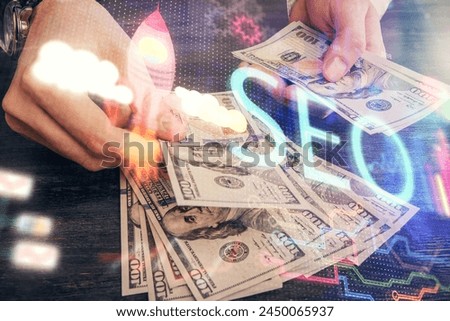 Multi exposure of seo drawing hologram and us dollars bills and man hands.