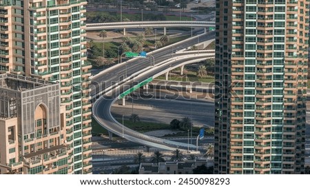 Dubai Marina highway exit between skyscrapers, spaghetti junction aerial view. Traffic on a bridge with modern towers