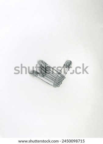 Premium photo of silver locking safety pins isolated on a white background.