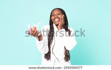 black african american adult woman wearing bathrobe and holding cosmetic products
