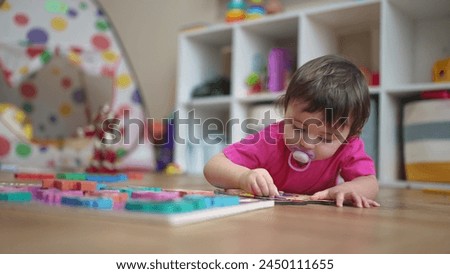 little daughter plays with toys on floor, develops fine motor skills. little daughter learning to lifestyle insert toy pictures into slots. happy family child dream concept