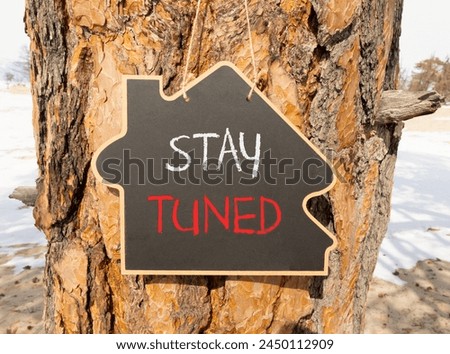 Stay tuned symbol. Concept words Stay tuned on beautiful black house blackboard. Beautiful tree background. Business, support, motivation, psychological and stay tuned concept. Copy space.