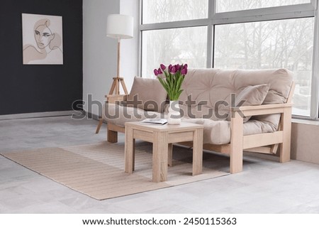Cozy living room with picture on wall, sofa and tulips