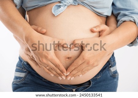 Woman pregnant belly being held by hands