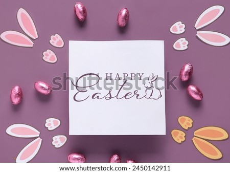 Easter greeting card, chocolate eggs and bunny ears on color background