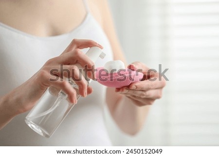 Washing face. Woman applying cleansing foam onto brush against light background, closeup. Space for text