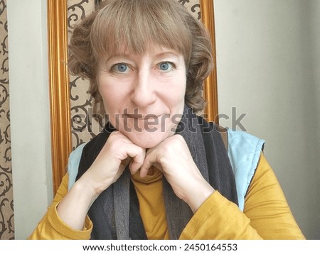 Portrait of cute blonde girl indoors. Funny middle-aged woman posing and taking selfie indoors