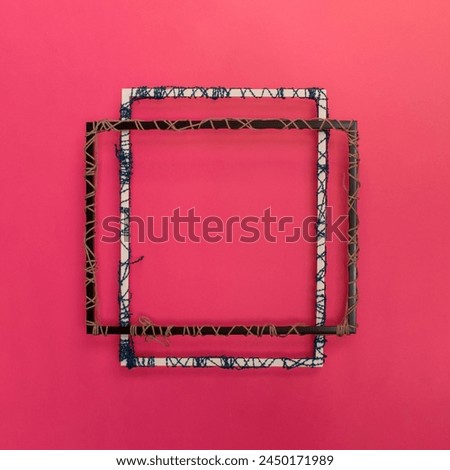 Creative picture frame concept with wool. Pink background with copy space. 