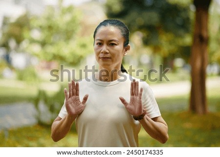 Portrait of mature woman doing tai chi breathing exercise