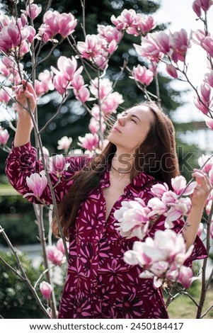Young woman in the park near a magnolia tree.