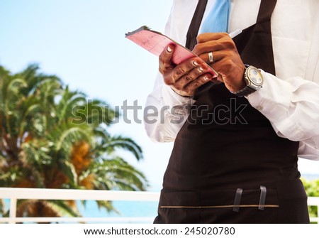 Outdoor cafe scene with waitress taking order. Close up Royalty-Free Stock Photo #245020780