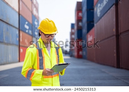 Asian and black engineers check cargo at shipping container