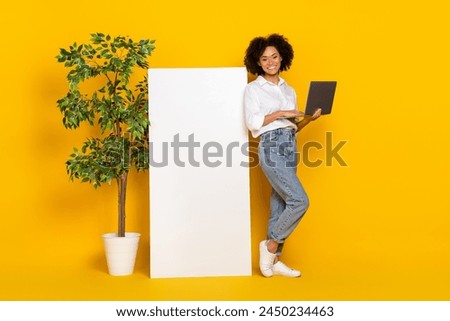Full length body size view of attractive cheery girl assistant using laptop copy space ad isolated over bright yellow color background