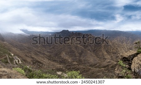 Panoramic view of Bentayga rock covered by clouds in the top of Gran Canaria . Gran Canaria. Canary islands Royalty-Free Stock Photo #2450241307