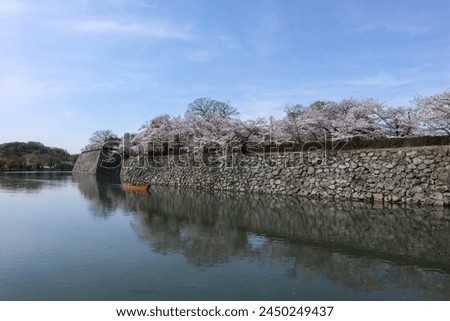 Boatman punting the boat for tourists to enjoy the Sakura view along the Himeji castle at spring season in Japan