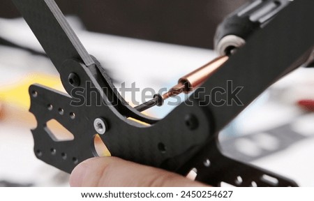 Tightening screws into carbon body of fpv DIY copter Royalty-Free Stock Photo #2450254627