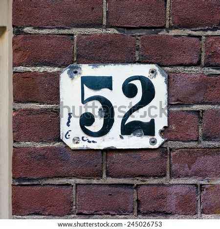 house number fifty two. Black numerals on a white plate