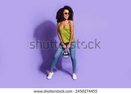 Full length photo of gorgeous young girl sunglass hold discoball wear trendy green sequins outfit isolated on purple color background