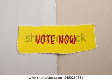 Vote now words written on ripped yellow paper with paper background. Conceptual vote now symbol. Copy space.