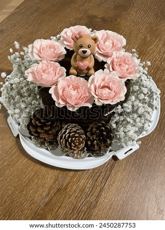 an amazing Birthday cake with a teddy bear and pink roses.