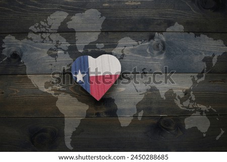 wooden heart with national flag of texas state near world map on the wooden background. concept