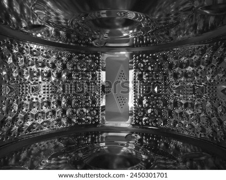 Perforated stainless steel. Macro photo of shiny technological metal surface. Precision foundry. Inside view of washing machine drum. Abstract metallic background for technology and industry.