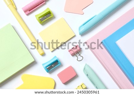 Flat lay with colorful school stationery and notebook on white background, top view
