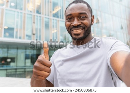 African American man with smartphone having video call on street in city. Guy blogger streaming chatting in social network. Man having virtual meeting vlog online chat outdoor Selfie webcamera view Royalty-Free Stock Photo #2450306875