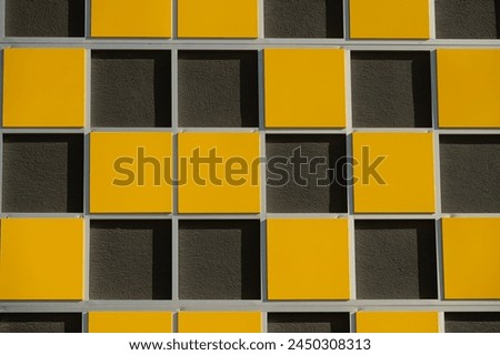 Close-up picture of the texture of the building wall. Yellow and black colours on the building wall.