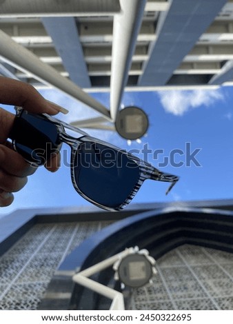 Summer sun aesthetic vibey photo with sunglasses and mosaic building