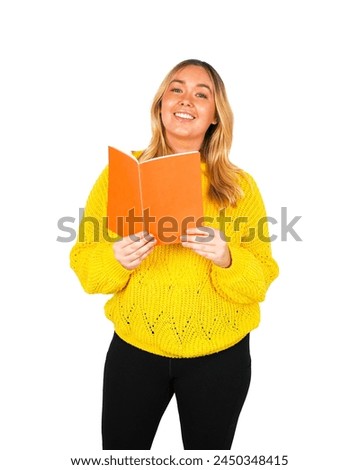 Beautiful young blonde female teacher holding an orange book while wearing a yellow jumper against a white background