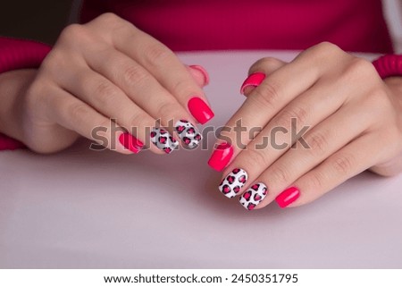 
Beautiful female hands with pink manicure nails, leopard print design on white background