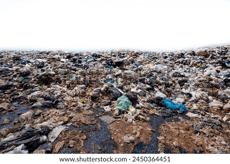 Big pile of trash on a white background Mountains of plastic waste, old rags, and scraps are thrown away on roadsides and public places. Household waste that is difficult to decompose causes pollution Royalty-Free Stock Photo #2450364451