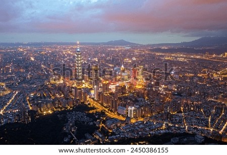 Aerial skyline of Downtown Taipei at sunset, the vibrant capital of Taiwan, with 101 Tower standing out amid modern skyscrapers in Xinyi Commercial district and city lights dazzling under twilight sky
