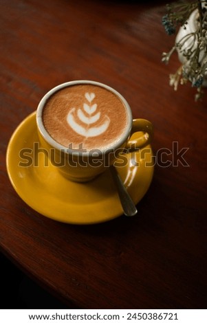 coffee latte picture of tulips on a beautiful yellow cup
