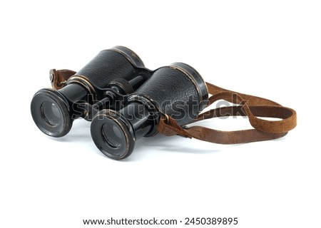 A pair of antique black binoculars with brown leather straps is showcased against a white background