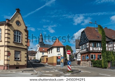 Streets, forks in the road, old houses partly with half-timbering and a church with a steeple in the old town area of Bonames, a district in the north of Frankfurt am Main