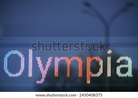 Olympia written on a LED screen in rainbow colors