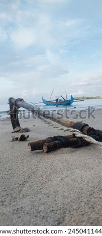 The anchor of a small fishing boat rests on the shoreline of Belitung's bathing birds