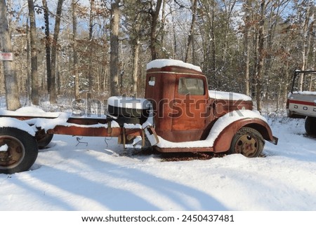 Rusted red vintage truck, abandoned on a country service road in the snow