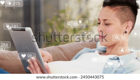 Image of social media icons with growing numbers over caucasian woman using tablet. Social media, communication and digital interface concept digitally generated image.