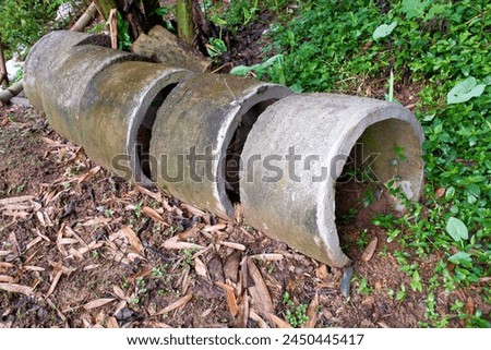 Several circular concrete culverts, on the side of the road, with a natural soil background, stock photo.