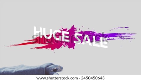 Image of huge sale text over denim trousers background. Sales, retail, shopping, digital interface, communication, computing and data processing concept digitally generated image.