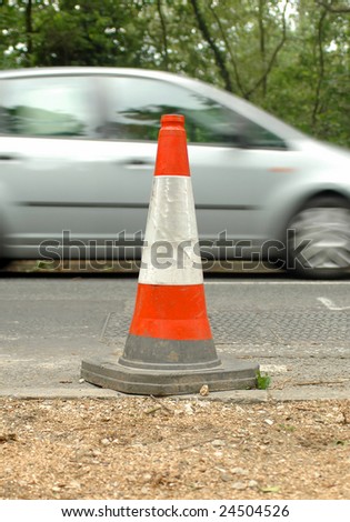 traffic safety cone and speeding automobile